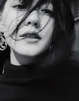 李诗颖倚靠光影之中，宽松白衬衫下的身姿若隐若现，诠释着慵懒与性感的极致平衡