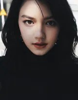 李诗颖侧身凝望，柔和的侧光勾勒出她高挺的鼻梁与深邃的眼窝，交织出静谧而神秘的氛围