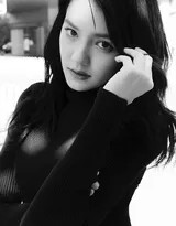 李诗颖以手轻抚面颊，在强烈光影分割下，姿态充满戏剧张力，展现出静谧中的内在力量