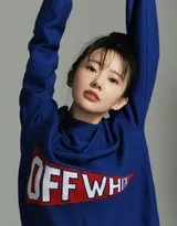 刘萌萌身着亮黄色毛衣，依靠在窗前沉思，温暖的色调映衬出她姣好的面容