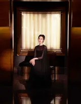 光影勾勒刘诗诗精致侧颜，她身着黑色礼服坐于琴凳，宛如即将奏响夜曲的音乐家，氛围静谧而富有故事感
