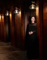 刘诗诗背对镜头回眸，黑色礼服露背设计展现优美肩颈线，与钢琴的曲线构成和谐画面，眼神故事感十足