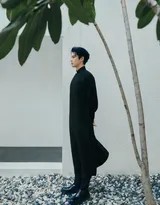 王鹤棣回眸瞬间，身后是延伸的园林月洞门，光影在其身上形成完美分割，故事感十足