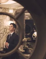 置身于柔和背景中，盛一伦身姿舒展，西装下摆随动作划出优雅弧度