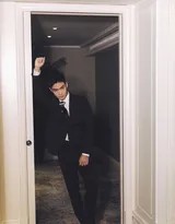 暖色调光线下盛一伦微扬下颌，嘴角噙着一丝若有似无的自信浅笑