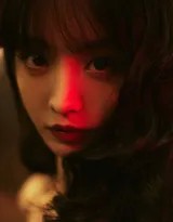 低角度仰拍中，田曦薇手持红伞行走于湿漉地面，裙摆轻扬，上方灯光形成炫目光晕，如同暗夜中的孤独仪式