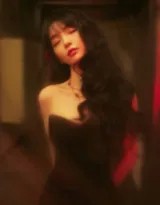 冷调街灯下，田曦薇背靠铁门，红伞轻搭肩头，仰望雨丝，侧脸轮廓在逆光中如精美剪影，弥漫诗意般的孤寂