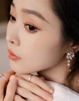 暖色调光影中，宋轶嘴角噙着浅笑，指尖轻触下颌，白色长裙如月光倾泻满身