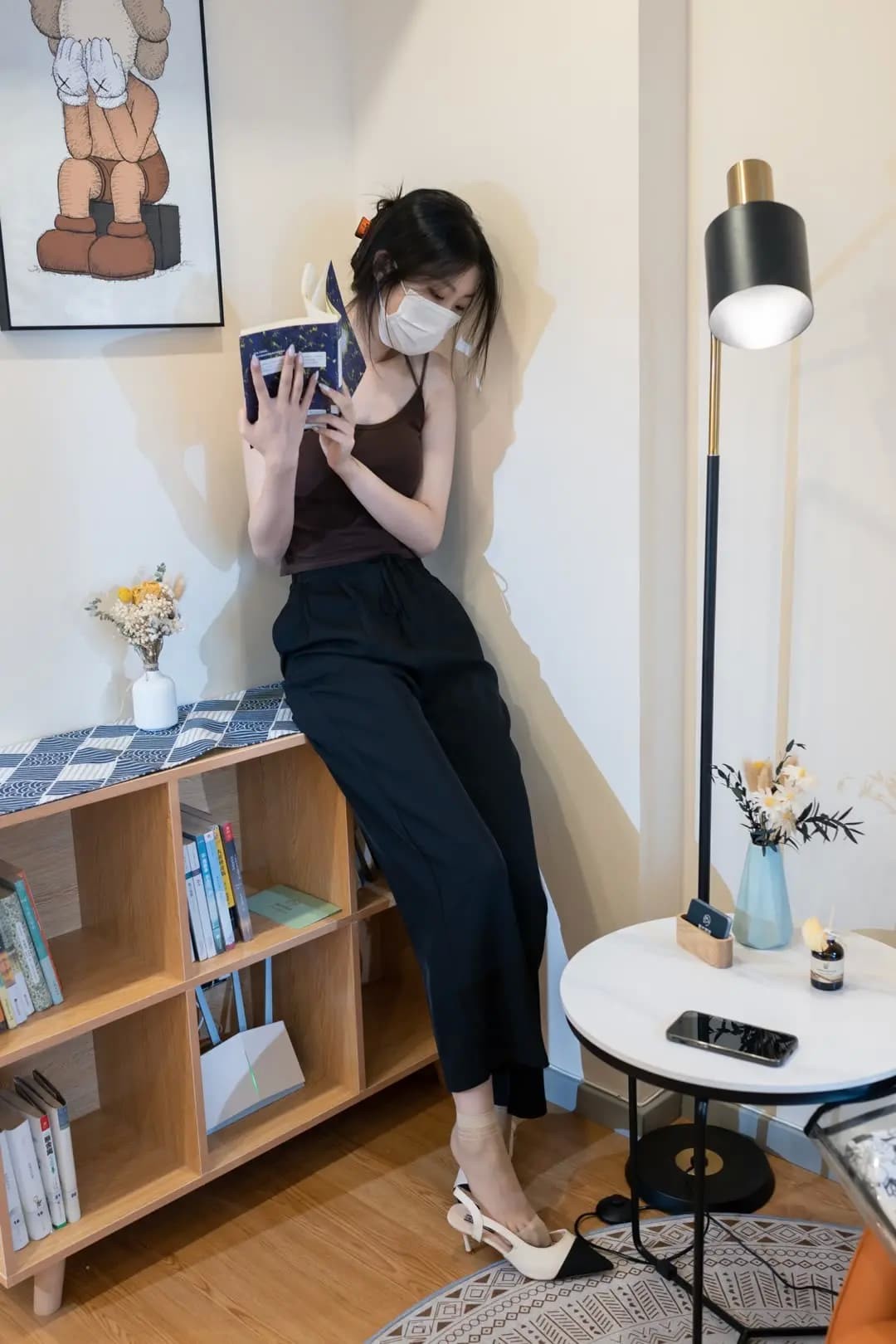 专注阅读中露背装增添休闲魅力，背景简约凸显人物优雅姿态