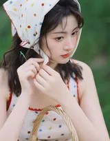 女孩蹲在溪边的岩石上，波点裙摆如花朵般铺散，她伸手轻触清凉的溪水，水面倒映着裙子的波纹和她专注的侧脸，静谧而充满探索的童趣。