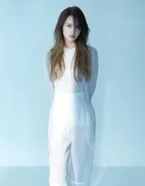 杨丞琳倚靠于简约背景前，姿态舒展而自信，一抹浅笑中蕴含着洞察世事的通透与接纳自我的平和