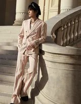 秋日林荫道上，朱一龙身着全套粉色条纹西装安然行走，贝雷帽与落叶构成一幅宁静和谐的秋日画卷