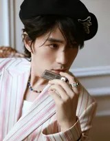 朱一龙戴着贝雷帽漫步于巴黎街头，粉色西装外套在阳光下质感十足，他面露浅笑，风度翩翩