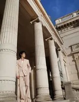 朱一龙微微仰头沐浴在巴黎的阳光下，粉色西装与贝雷帽的搭配展现出独特的复古浪漫情怀