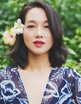 朱丹轻倚公园廊架，蓝色裙摆随风轻扬，她目光柔和望向前方，神态恬静而放松