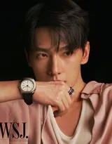 杨洋身穿亮绿色高领衫凝视镜头，身后斑驳光影营造出静谧而深邃的秋日氛围