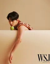 杨洋以慵懒姿态坐于光影交织处，身着格纹西装，展现出兼具复古与摩登的独特气质