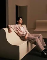 杨洋倚靠椅背，在柔和光线下展现深邃侧颜，针织衫的细腻纹理与静谧氛围相得益彰