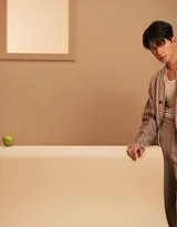 杨洋身着复古廓形风衣侧身而立，衣角随风微动，展现出宛如电影画面般的动态故事感