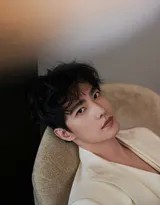 杨洋身着白色休闲西装侧身凝视镜头，光影勾勒出其俊朗面部轮廓与沉静气质