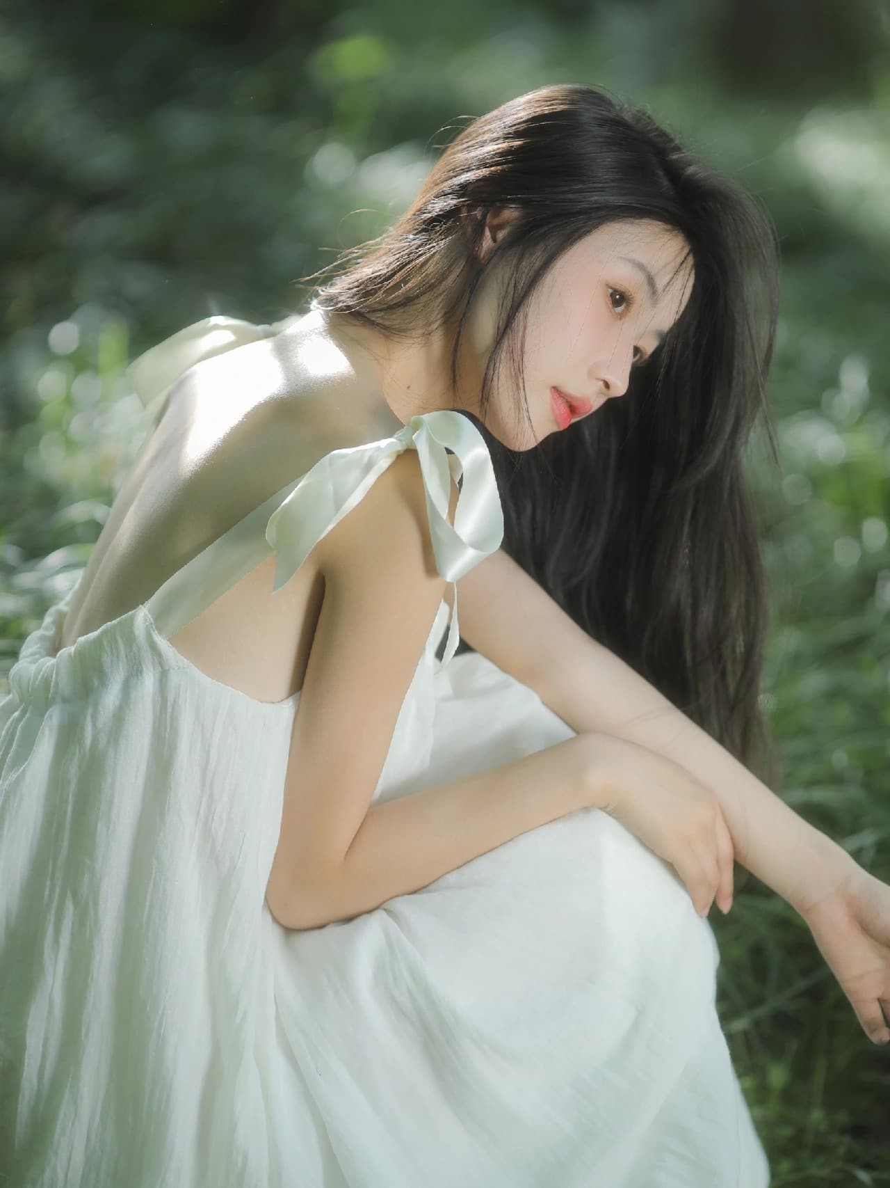 一位身着白裙的少女在夏日森林中闭眼微笑，阳光透过树叶洒在她的发梢，如同林间精灵