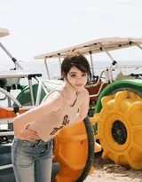 祝绪丹赤足漫步于浅滩，回眸一笑，浪花在她脚边绽开，画面洋溢着无忧无虑的欢快