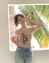 祝绪丹漫步沙滩，牛仔裤脚微卷，背影在落日余晖下拉长，充满宁静的旅途诗意