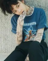 谭松韵身穿简约白色运动外套，扎着清爽丸子头，于暖阳下的街头侧身回眸，眼神清澈灵动，尽显邻家少女般的亲切与活力。