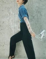 谭松韵坐在健身房地面进行伸展，身穿简约运动装束，丸子头造型清爽，表情轻松自然，展现出运动后的舒畅与惬意状态。