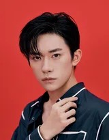 易烊千玺手持复古电话，眼神带有一丝戏谑与故事性，蓝色衬衫与红色背景构成经典配色