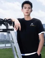 王鹤棣身穿炭灰色复古运动套装，在阳光下展露标志性的阳光笑容，尽显青春活力。