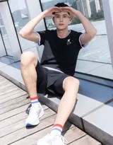 王鹤棣坐在台阶上休息，身穿简约运动装，姿态放松，笑容温暖，如同邻家学长般亲切。