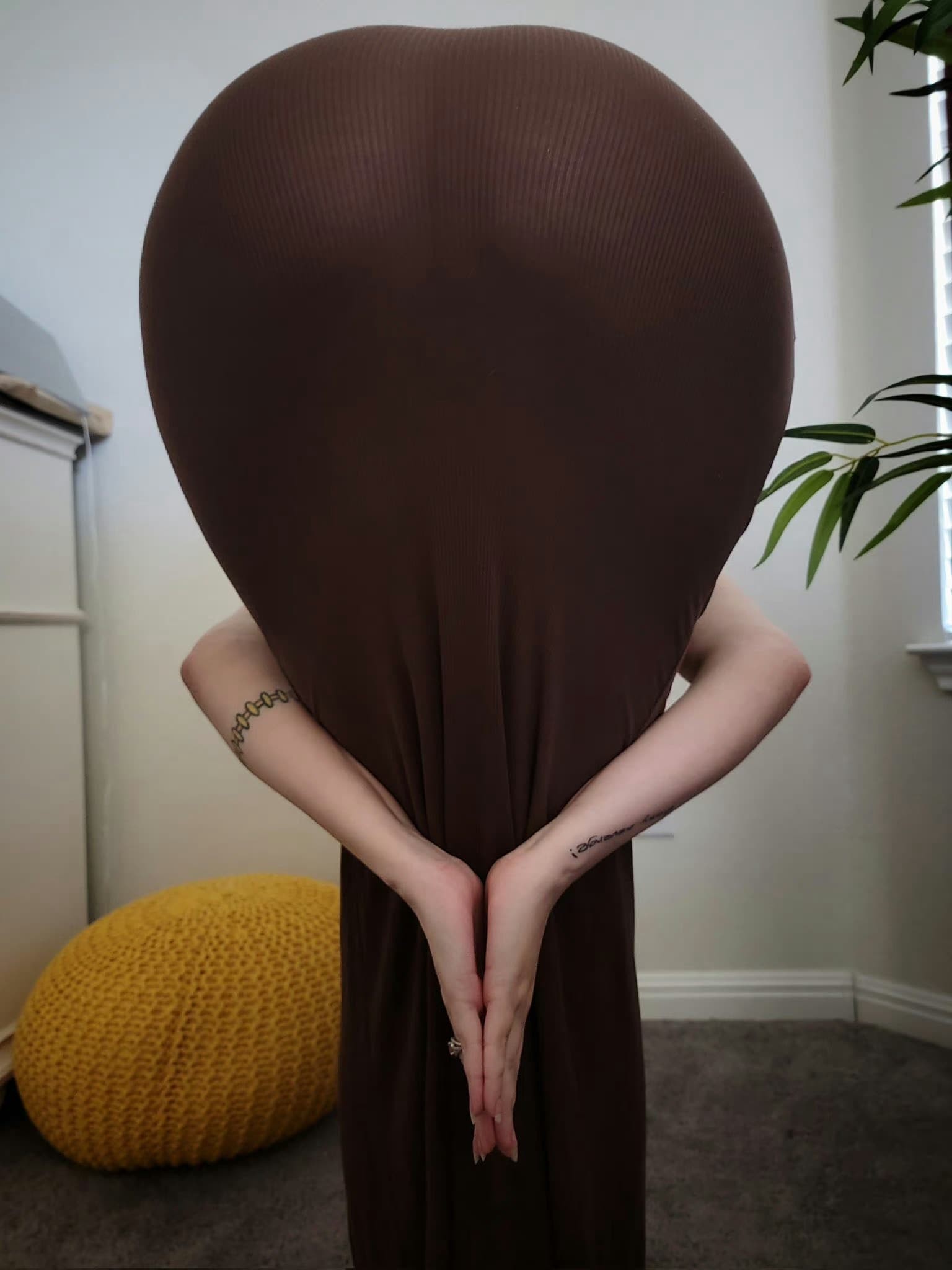 一位瑜伽练习者在家努力完成高难度后弯体式，身体形成充满力量的拱形，展现出惊人的柔韧与平衡。