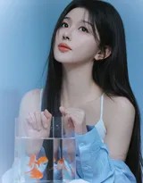 她侧身倚靠，蓝色针织衫随意搭在肩头，发丝被微风轻轻拂起，午后阳光在脸颊投下温柔光影。