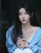 孔雪儿坐于地毯上，双臂轻环膝盖，蓝色吊带裙衬托出优美的肩颈线条，神情专注而温柔。