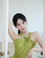 特写镜头下的祝绪丹，眼眸含笑似含星辰，橄榄绿衬托得肌肤胜雪，美得令人屏息