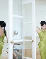 祝绪丹倚靠廊柱，光影分割明暗，她目光沉静望向镜头，优雅中透露出坚定力量