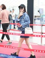 秦岚站在机场室外，整体穿搭以蓝白色调为主，清新如天空，她姿态放松，宛如一抹亮丽的都市风景。