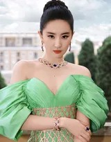 刘亦菲手提裙摆拾级而上，身姿挺拔如天鹅，翡翠长裙在阶梯上铺展如孔雀华羽，与古朴的石阶构成一幅充满动感与故事性的时尚画卷