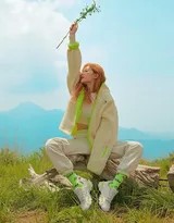 泫雅身穿條紋衫置身田野髮絲輕揚眼神溫柔眺望遠方