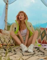 泫雅以天空為背景仰拍展現精致側顏與隨性捲髮