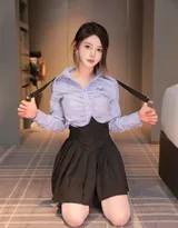 爱酱侧身回眸，蓝色衬衫松垮地搭在肩头，黑色背带裙的丝带轻轻垂落，眼神中带着一丝慵懒与俏皮的探索