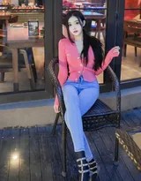 龙雪儿漫步街头，红色上衣如火焰般耀眼，牛仔裤紧裹修长双腿，高跟鞋轻点地面，尽显自信步伐