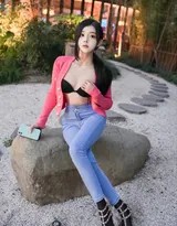 近距离拍摄龙雪儿上半身，红色上衣纹理细腻，锁骨线条优美，牛仔裤腰扣设计简约，整体造型干净利落