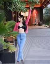 龙雪儿转身瞬间，红衣旋出弧线，牛仔裤后袋绣花点缀，高跟鞋跟部反射光线，动态感十足