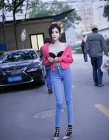 龙雪儿在街灯下驻足，红色上衣映照暖光，牛仔裤褶皱自然，高跟鞋阴影拉长，画面充满电影质感