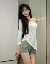 侧身微转展示牛仔短裤下修长美腿，白衣下摆随风轻扬，散发青春活力