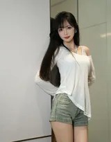 对镜回眸浅笑，牛仔短裤勾勒出曼妙臀线，白衣领口微露锁骨干练