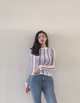 柔和光线下，模特侧身而坐，牛仔裤的纹理与室内温暖的色调交织，营造出静谧而富有故事感的私人氛围。