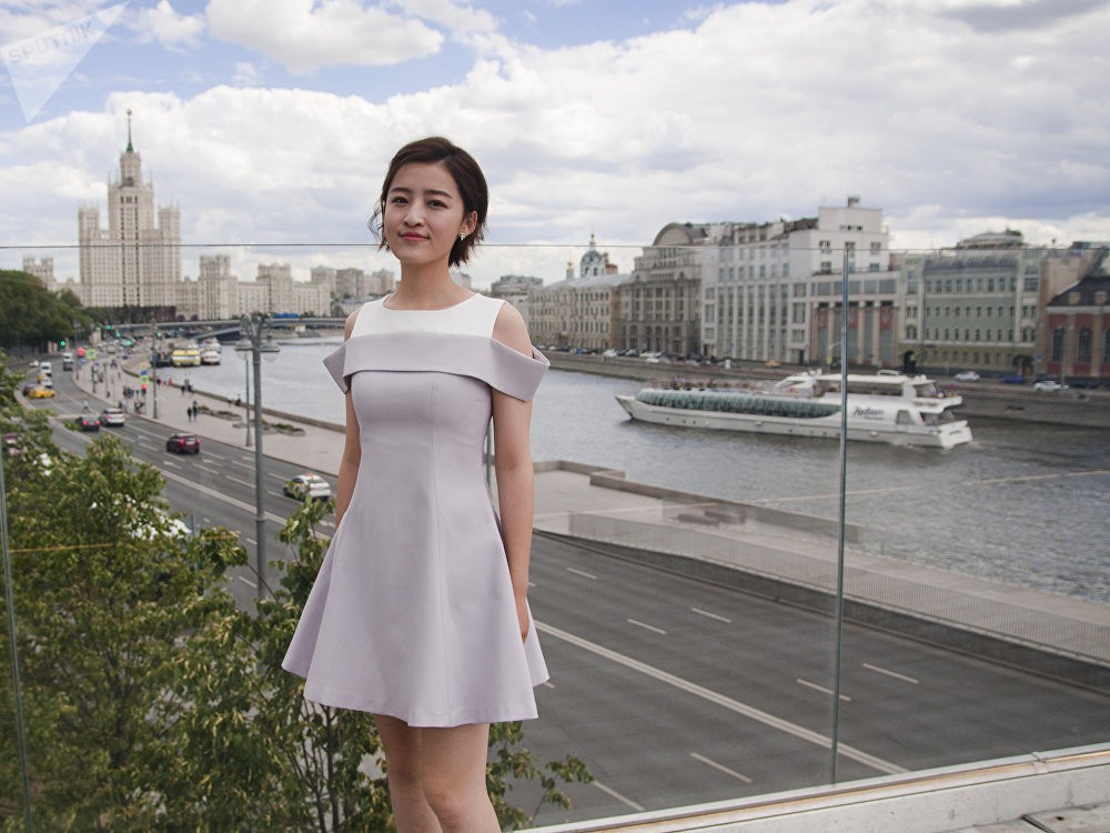 镜头特写杨茗茗未施粉黛的面容与修长美腿，阳光洒落，笑容清爽干净，洋溢着青春气息。